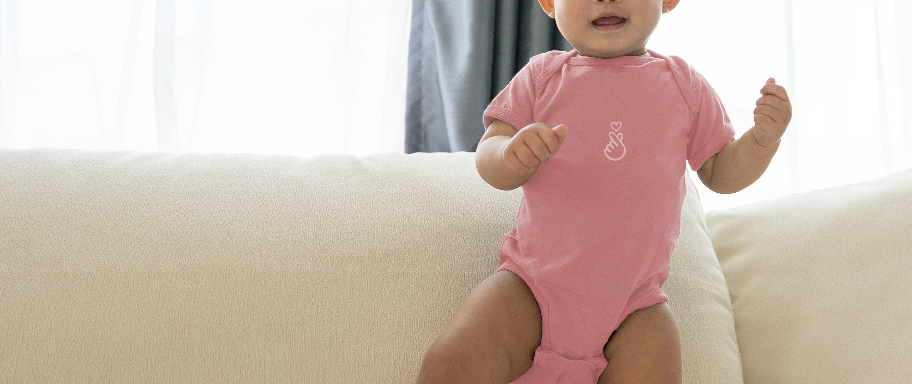 Baby in pink onesie with Asian love sign for Asian Baby Clothing