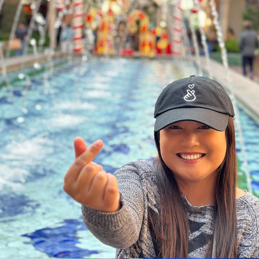 Black finger heart dad hat styled for casual Asian American look